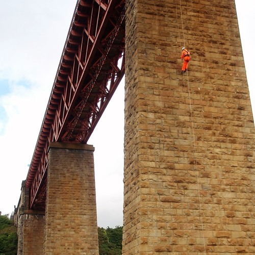 Image of maintenance inspection worker on a rope on a tower of the Forth Bridge